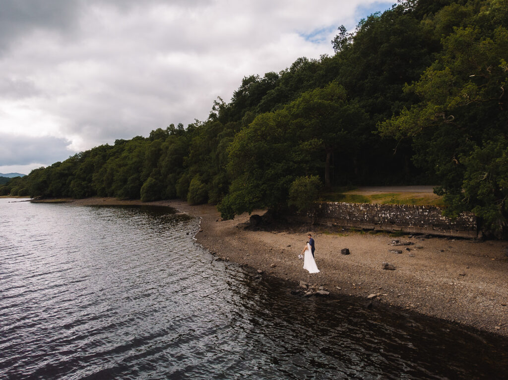Scenic lakeside landscape with couple walking along shore.