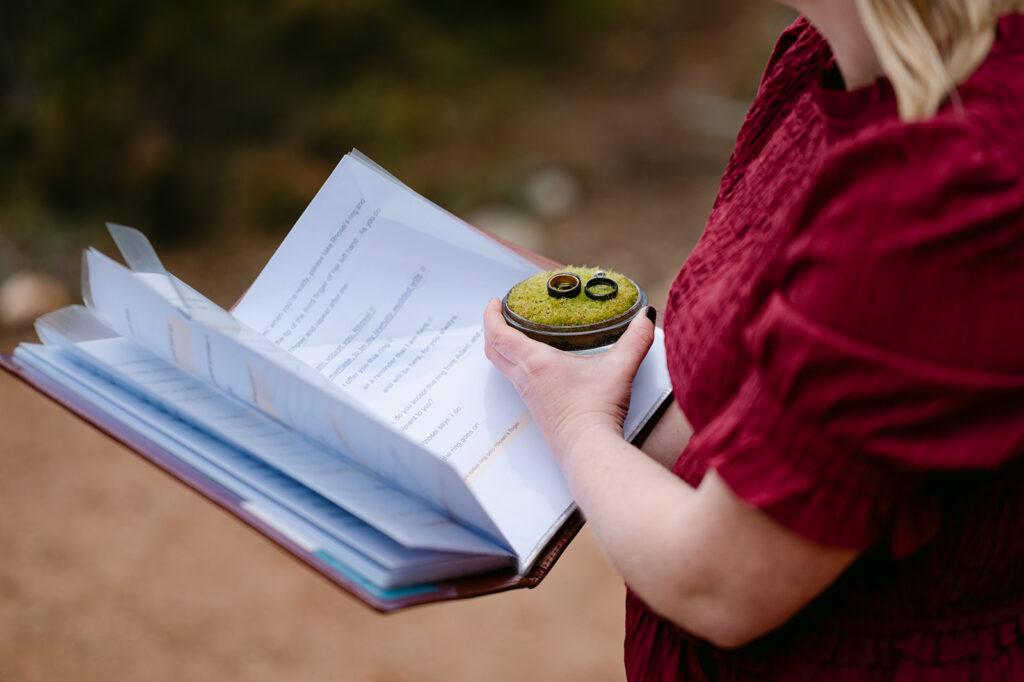 Person holding book and cupcake during relaxed wedding moment.