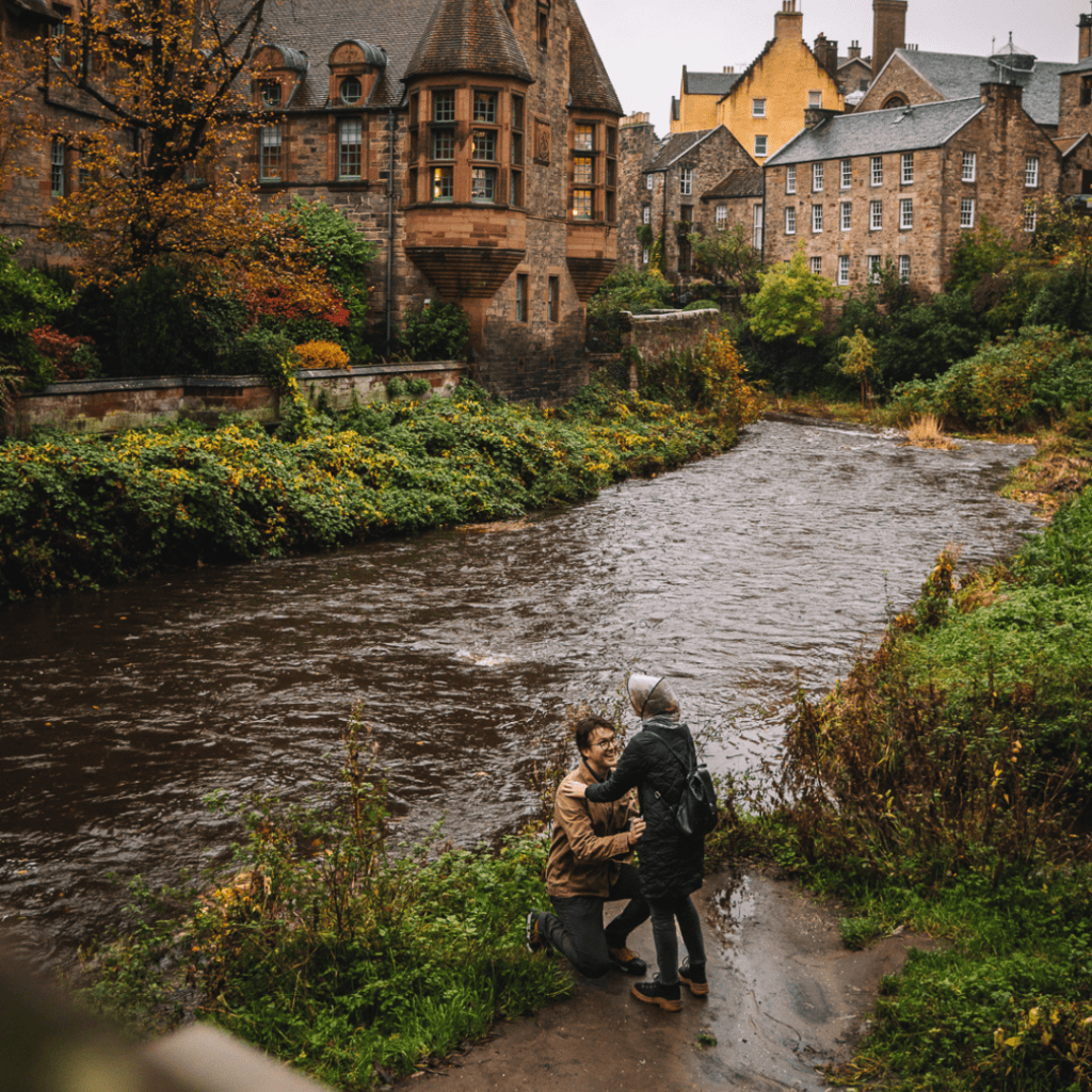 couple proposal in River flowing through Dean Village with historic buildings
