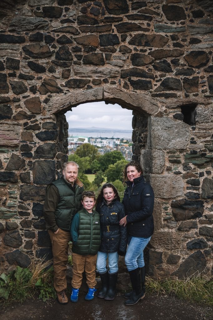 Family standing together framed by stone arch ruins