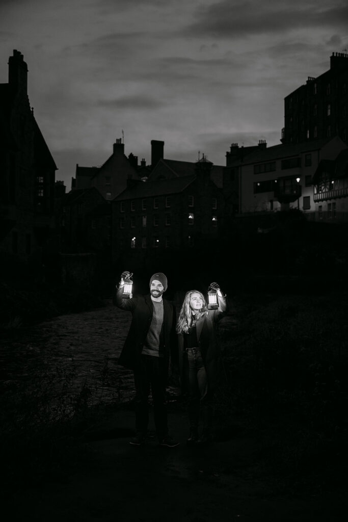 couple hold up lanterns to light their faces in dean village