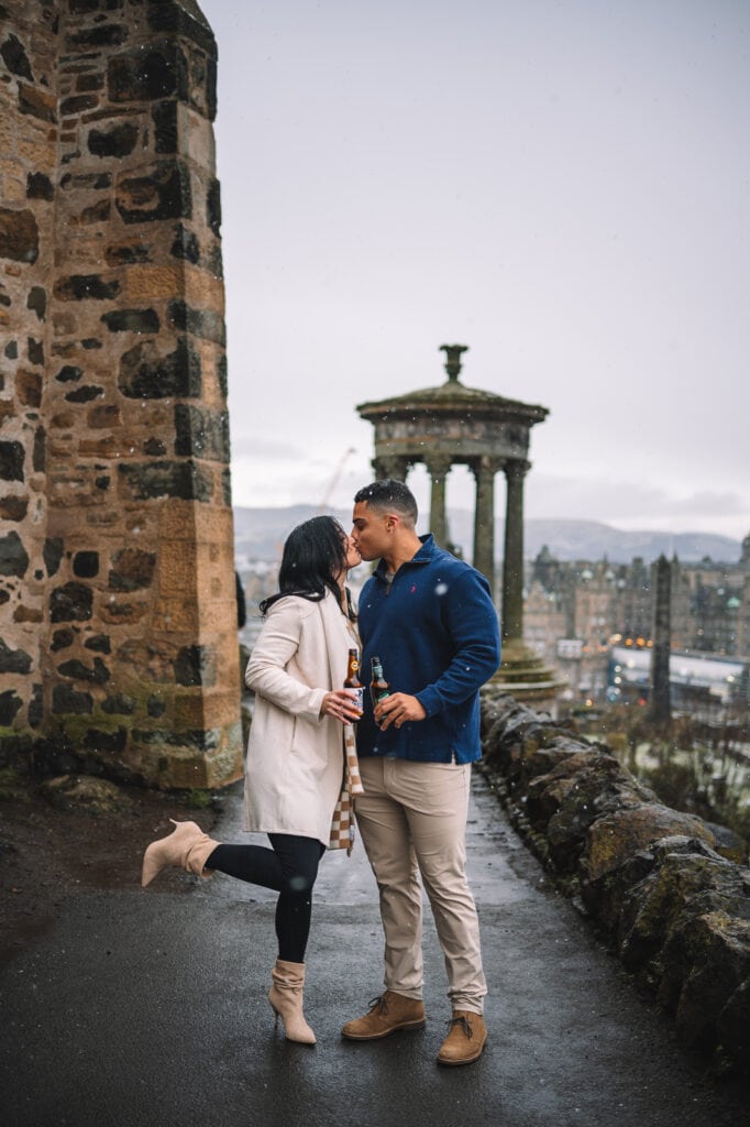 Couple embracing beside stone wall overlooking city