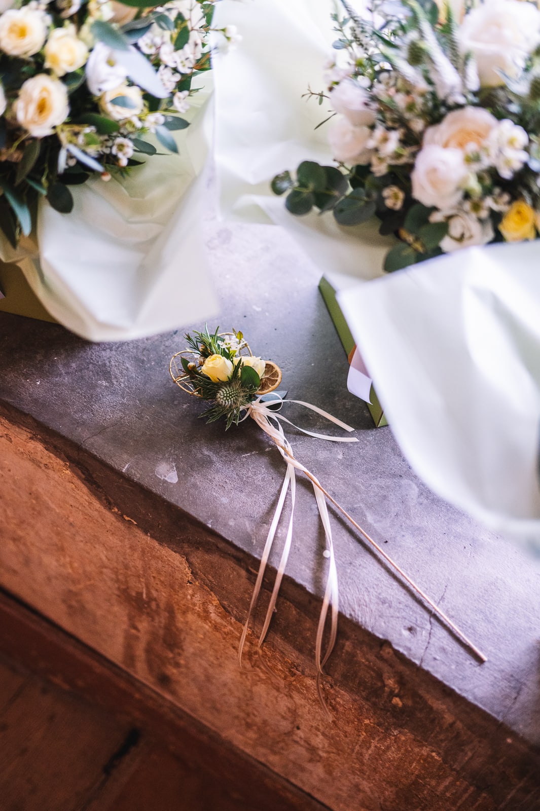 Wedding detail with bouquet and ribbons on stone ledge