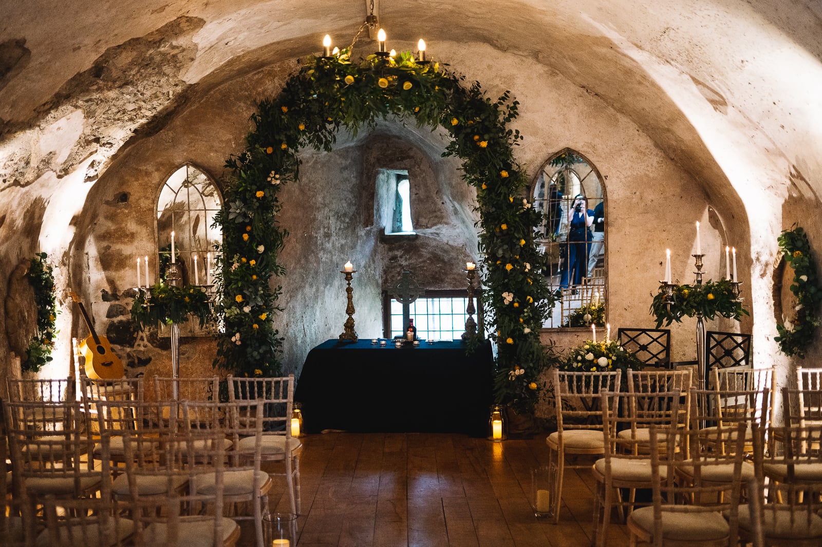 Intimate ceremony setup with greenery arch and candles