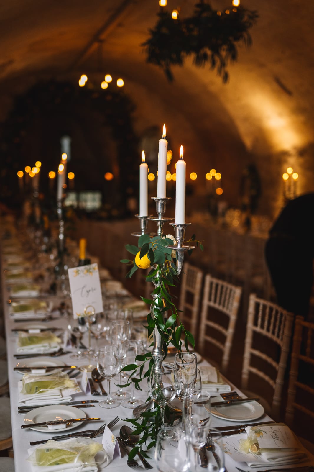Candlelit reception table in atmospheric stone cellar