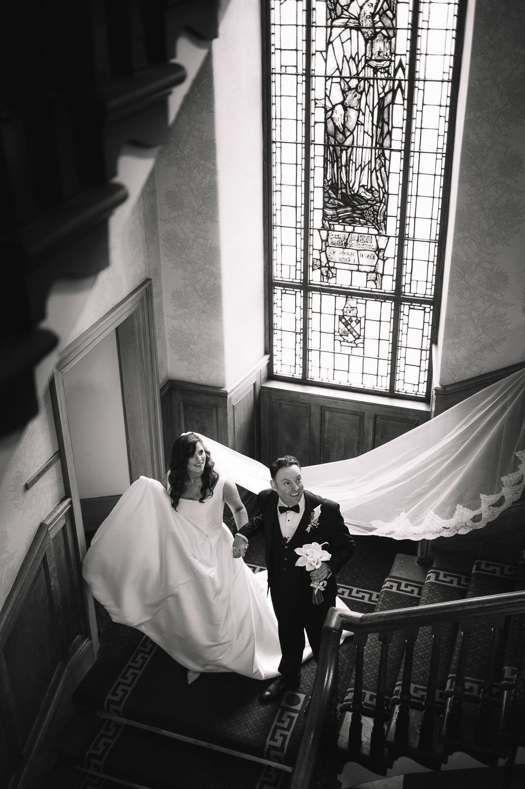 Bride and groom descending staircase together