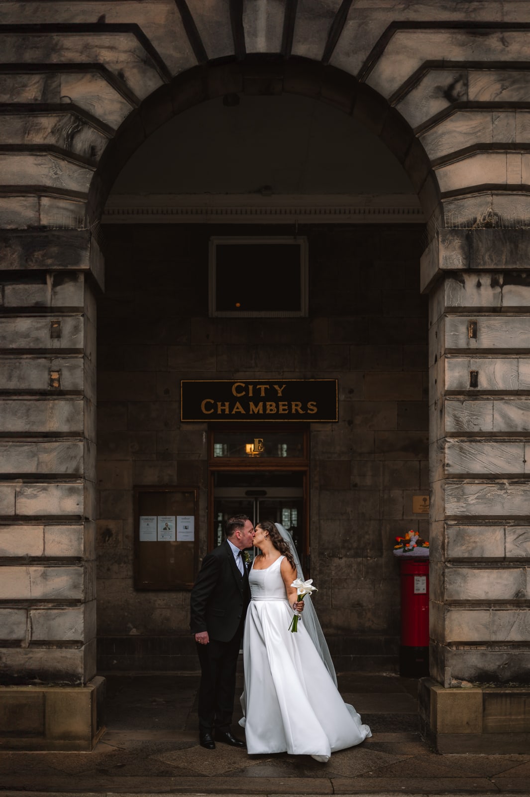 Bride and groom embracing outside City Chambers Edinburgh