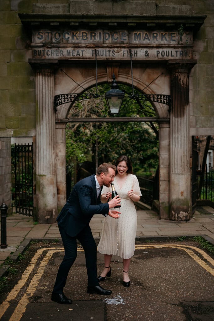 Couple laughing together beneath an ivy-covered archway