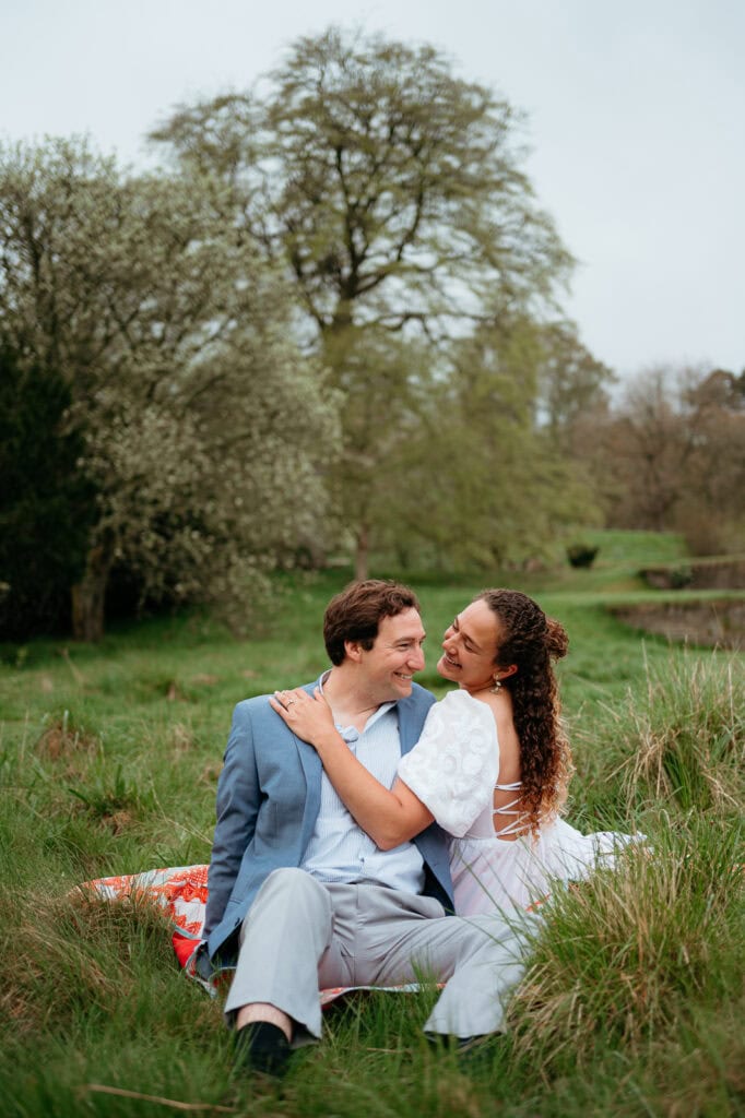 Couple embracing in a grassy countryside setting in Scotland