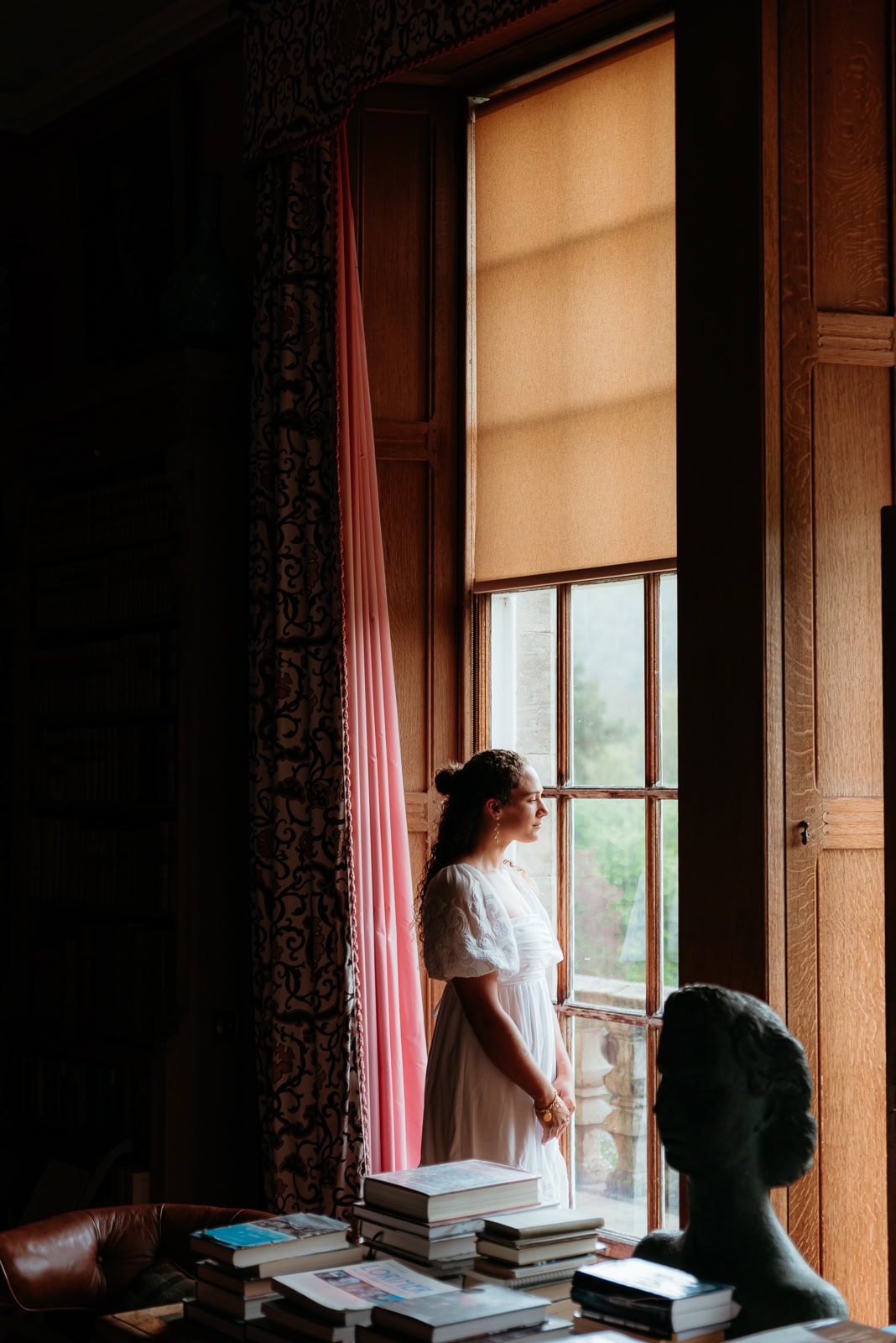 Bride standing by window in soft natural light indoors