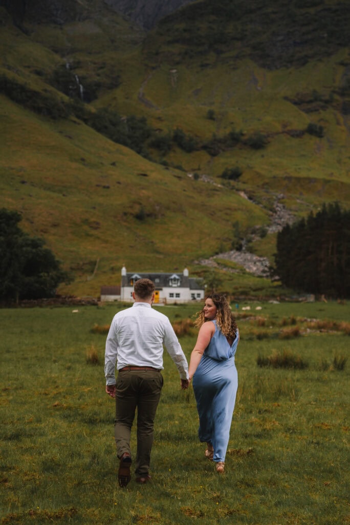 Couple walking together through Scottish Highlands landscape near a loch