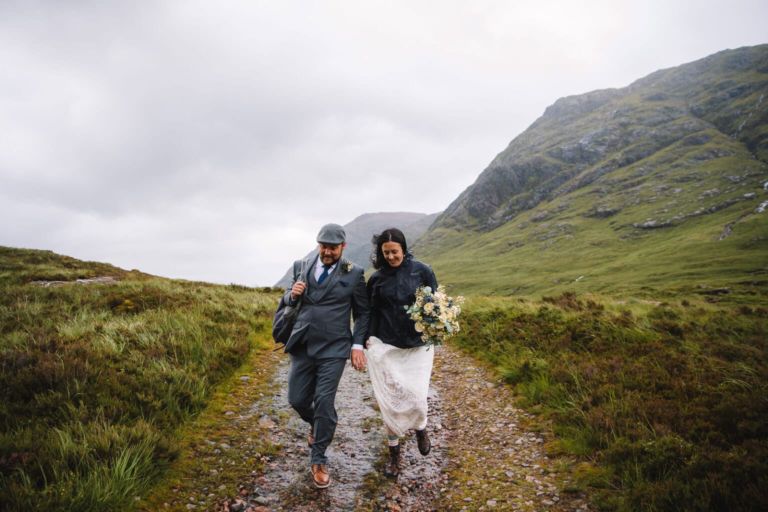 Bride and groom walking along a Highland path together
