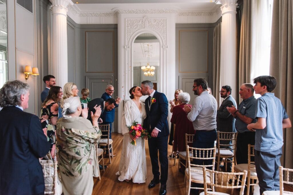 Guests congratulating couple inside ceremony room