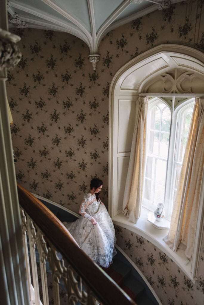 Bride sitting by window in softly lit room