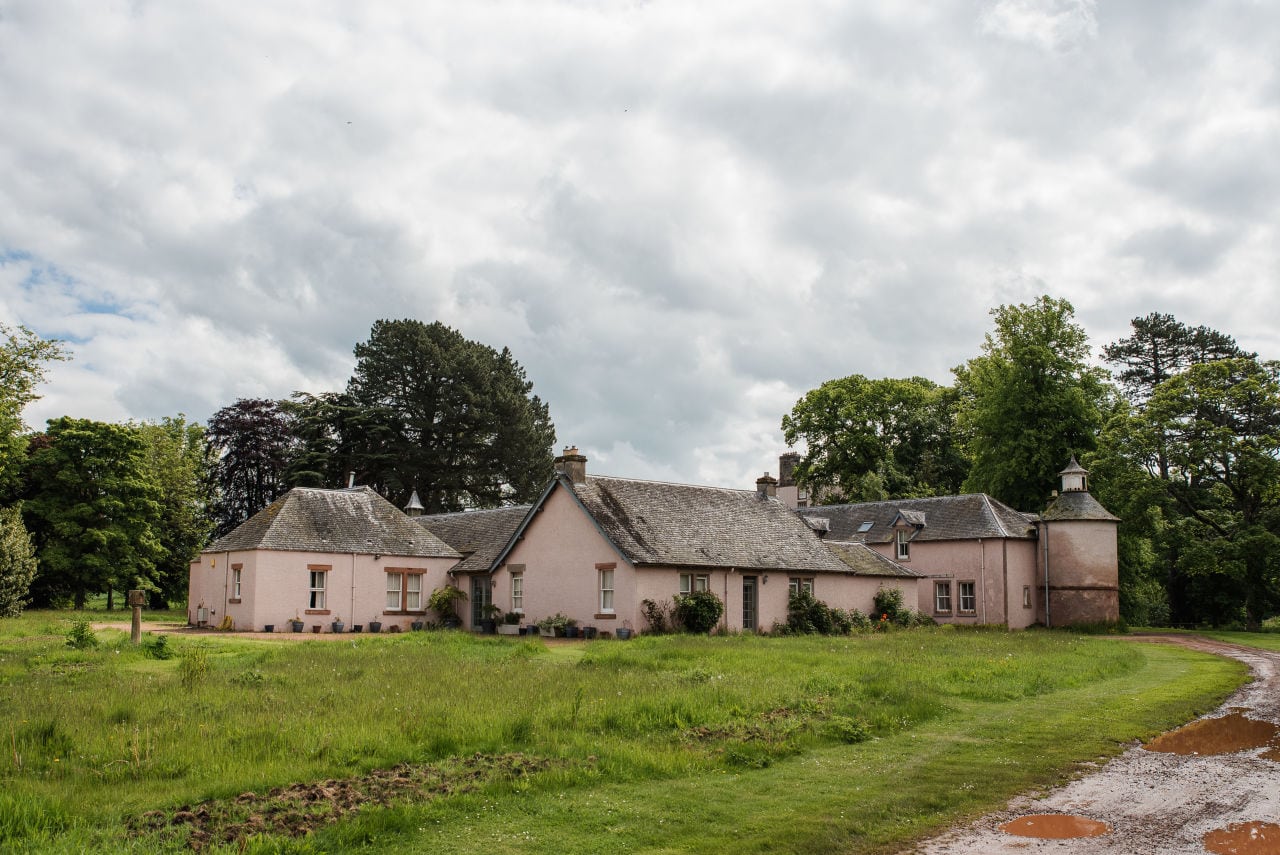 Rustic countryside wedding venue with stone buildings and green lawn