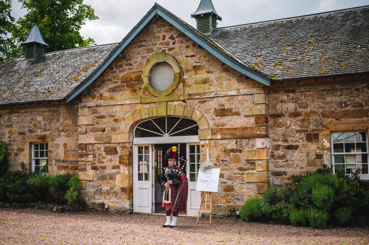Entrance of a countryside wedding venue with floral arrangements