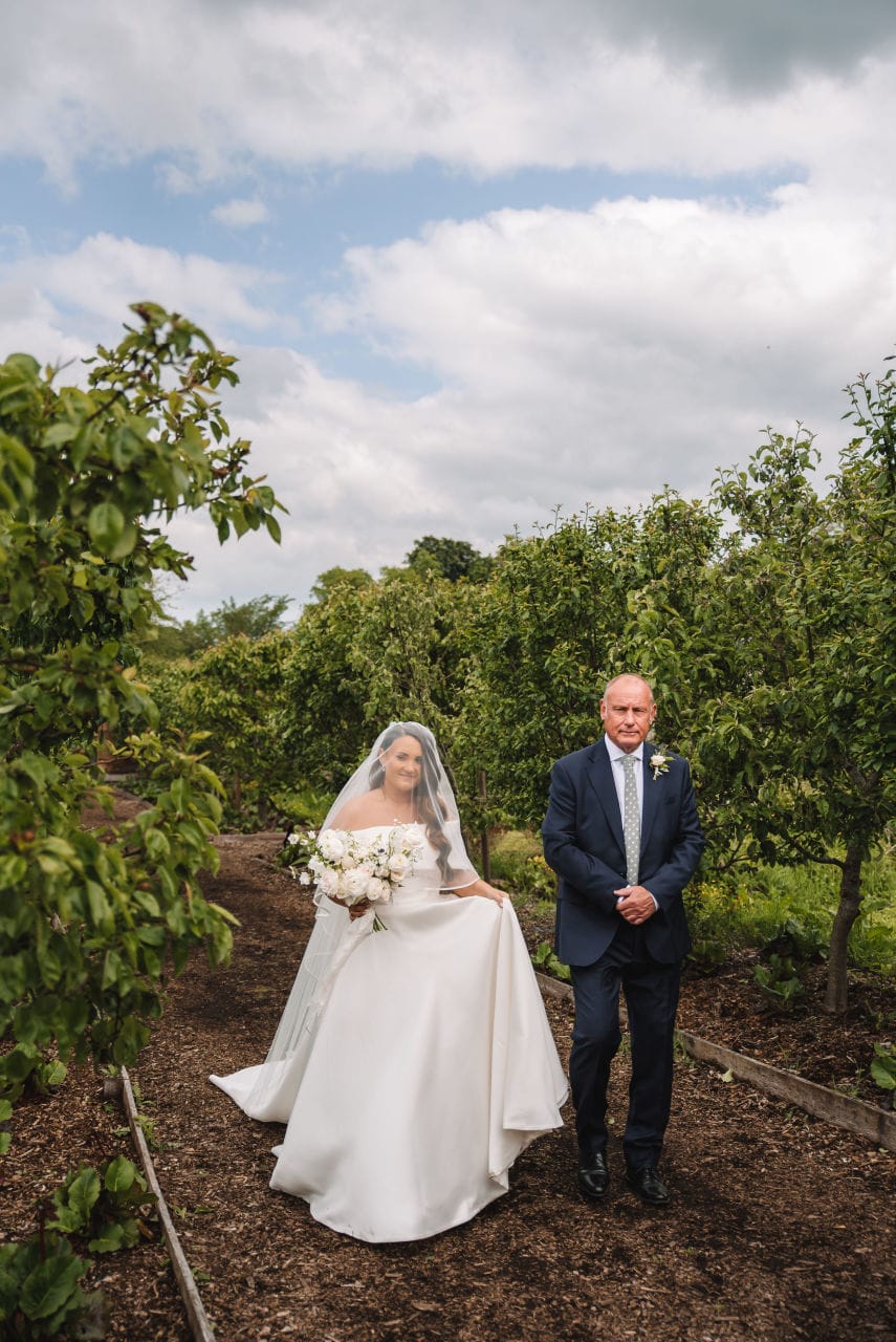 Bride and groom standing together in a garden before ceremony
