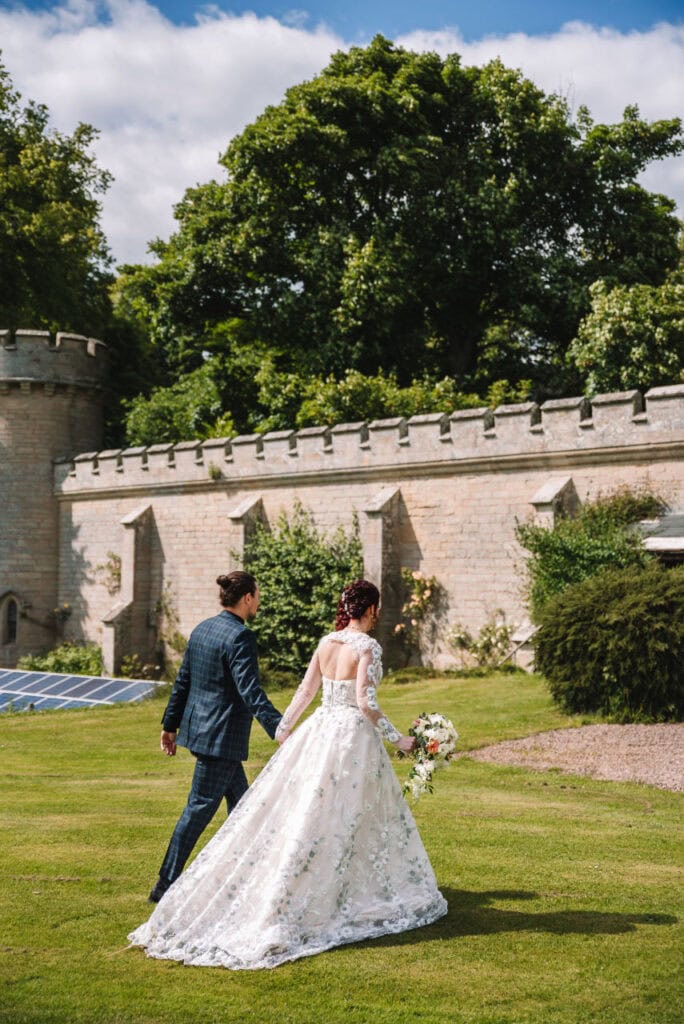 Couple walking together beside castle grounds