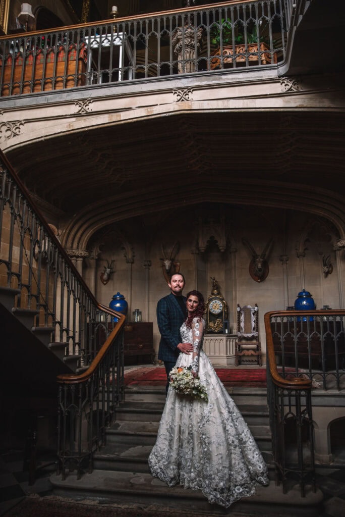 Couple standing on staircase inside castle interior