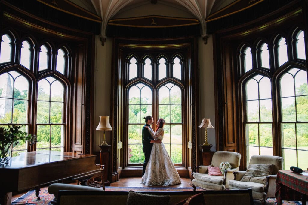 Couple embracing by large window in stately room