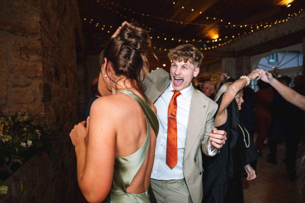 Guests dancing and celebrating during evening wedding reception