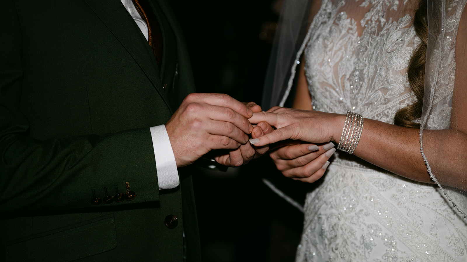 close up of rings on bride and grooms hands