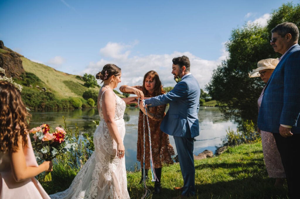 Couple exchanging vows outdoors beside river in Scotland