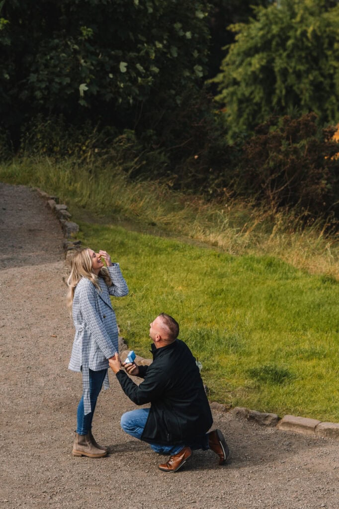 Couple celebrating proposal outdoors on path