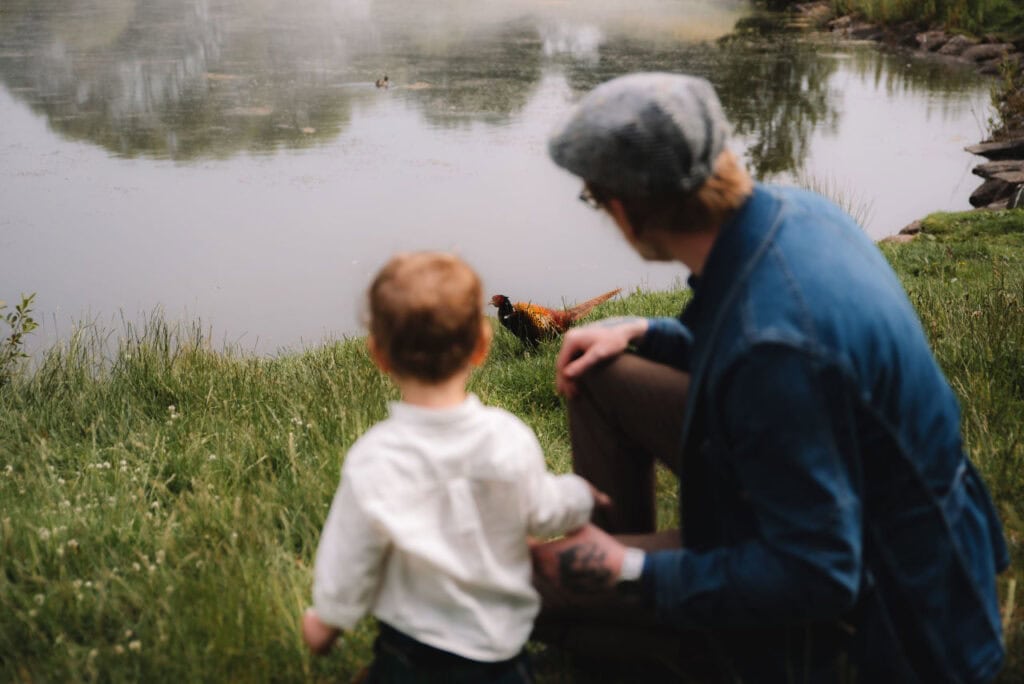  Parent and child standing beside riverbank