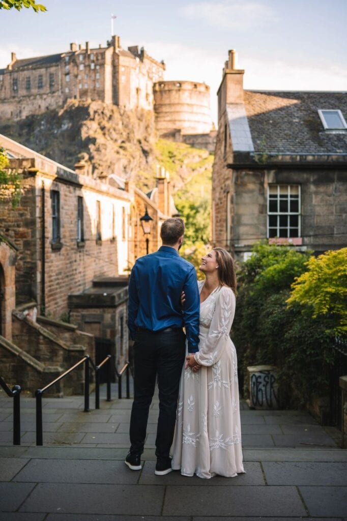Couple standing beside historic stone building
