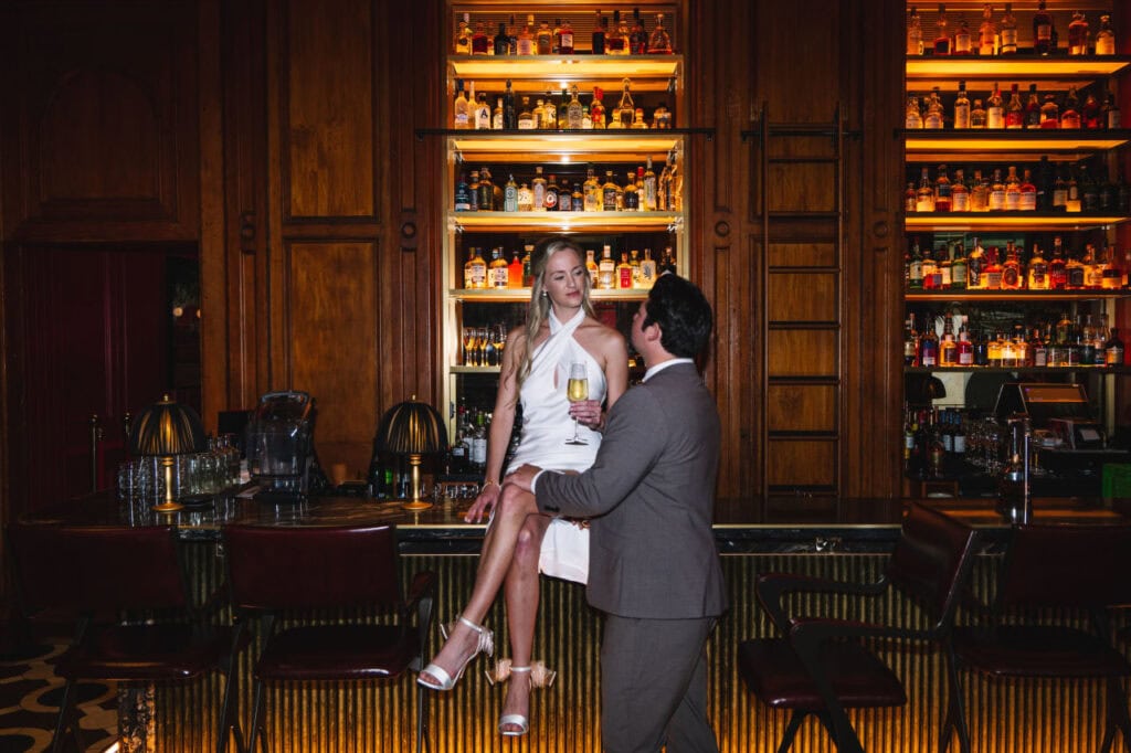 Couple posing together inside elegant bar interior