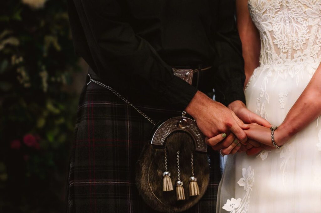 couple holds hands during wedding ceremony