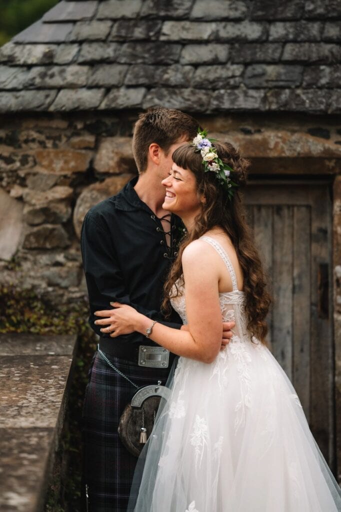 bride and groom cuddle at Neidpath Castle