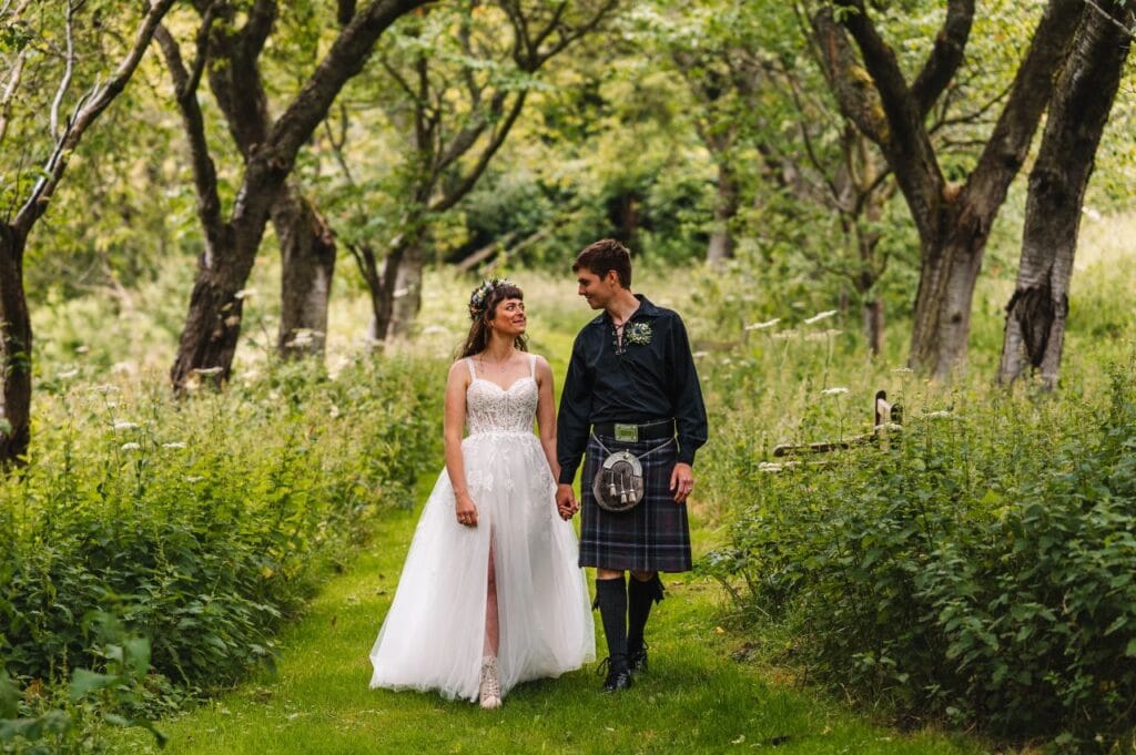 bride and groom walk through Neidpath Castle grounds