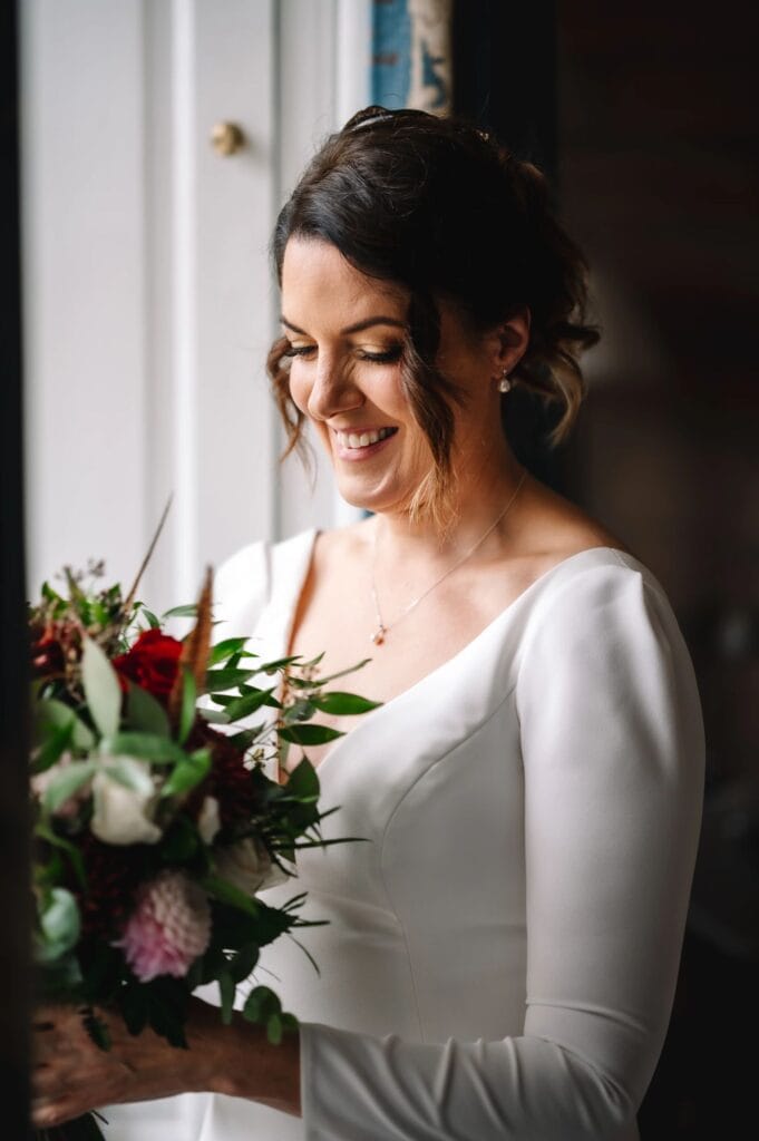 Bride smiling holding bouquet during getting ready