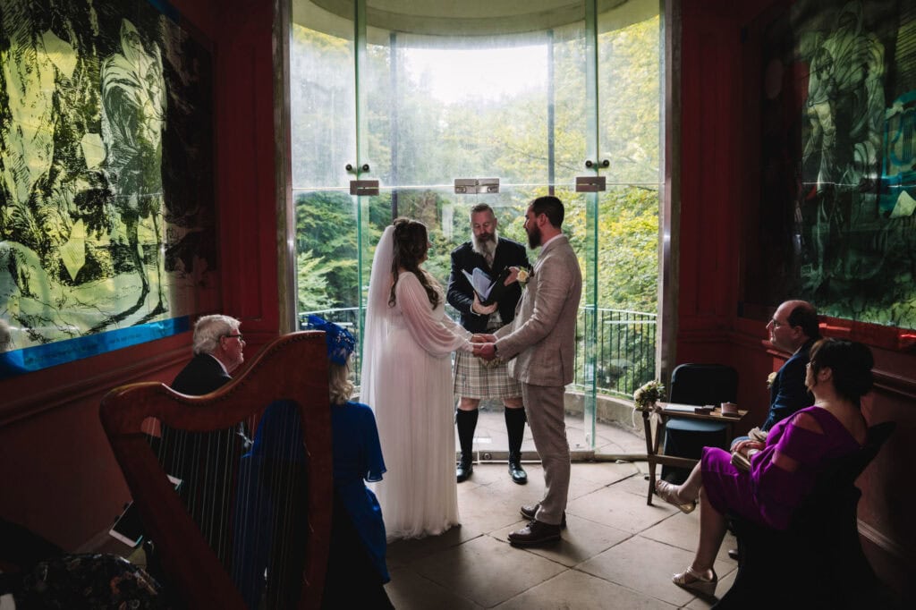 Couple exchanging vows during indoor ceremony