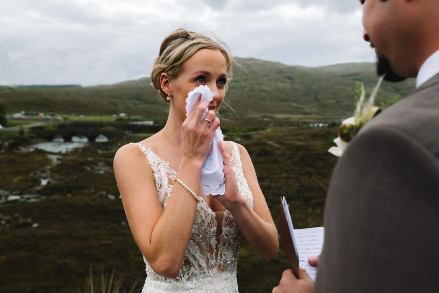 Bride wiping tears during emotional vow exchange