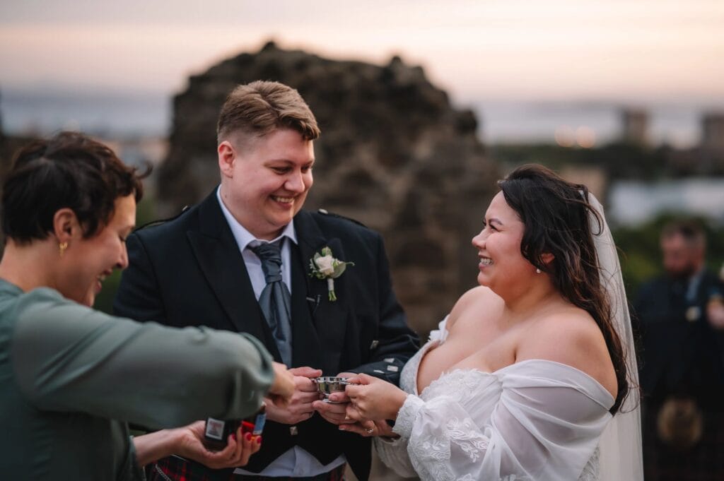 Couple exchanging rings during outdoor ceremony