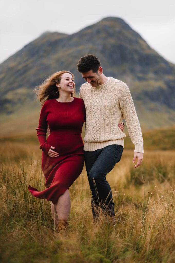 Couple walking hand in hand through grassy Highlands