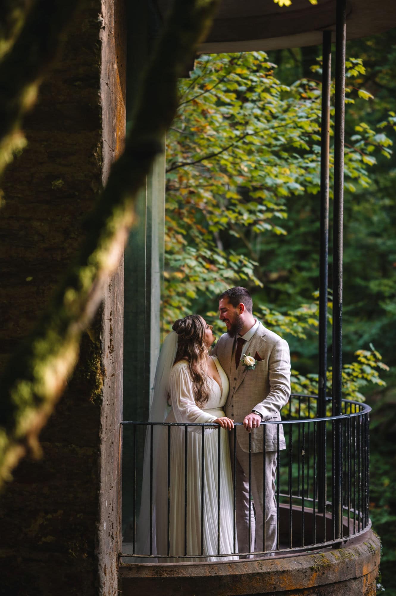 Couple embracing on balcony in woodland setting