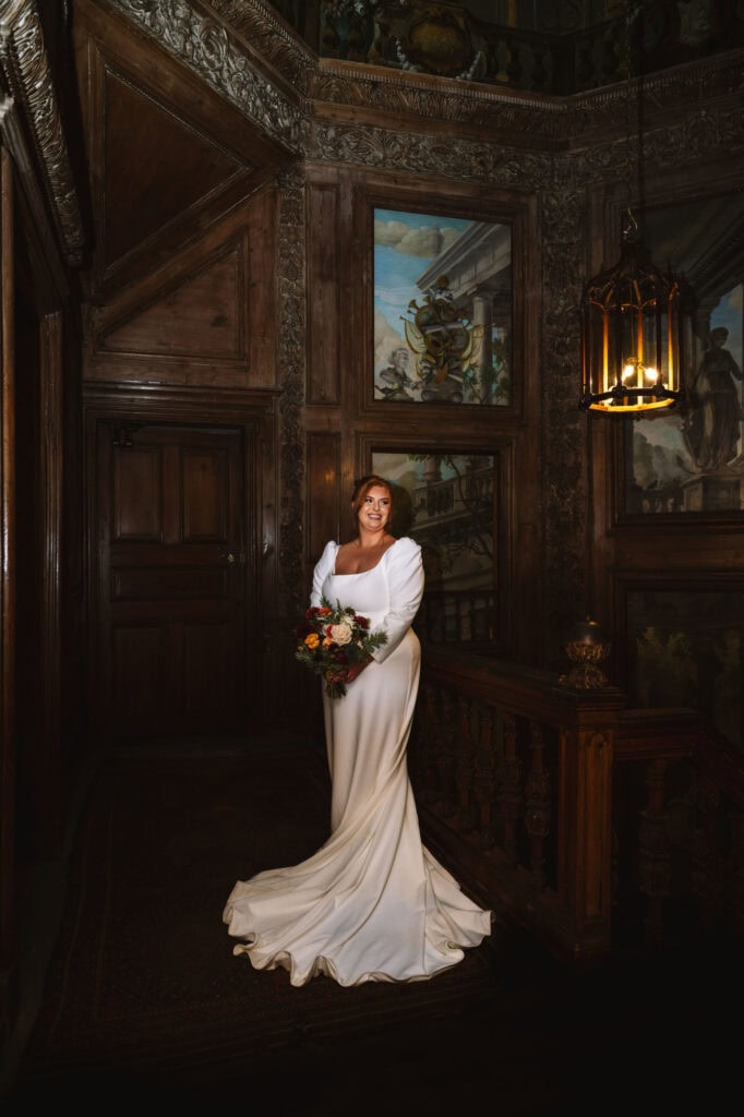 Bride posing alone in softly lit interior room