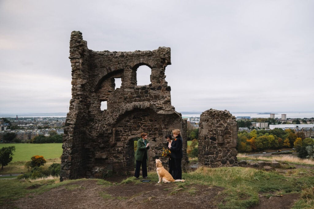 Couple with dog at historic castle ruins in Scotland