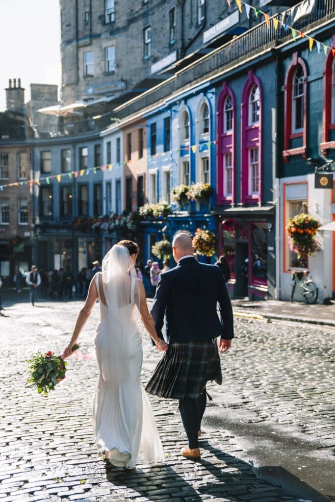 Couple walking through colourful Victoria Street in Edinburgh