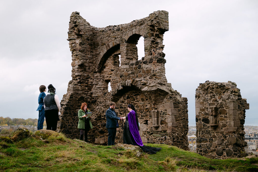 Guests gathered near historic ruins during outdoor ceremony.