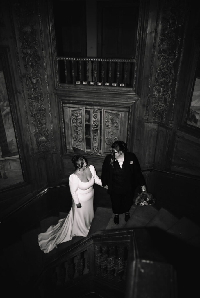 Black and white portrait of couple standing together in dimly lit interior.