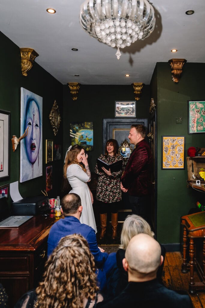 Couple exchanging vows in colourful intimate room