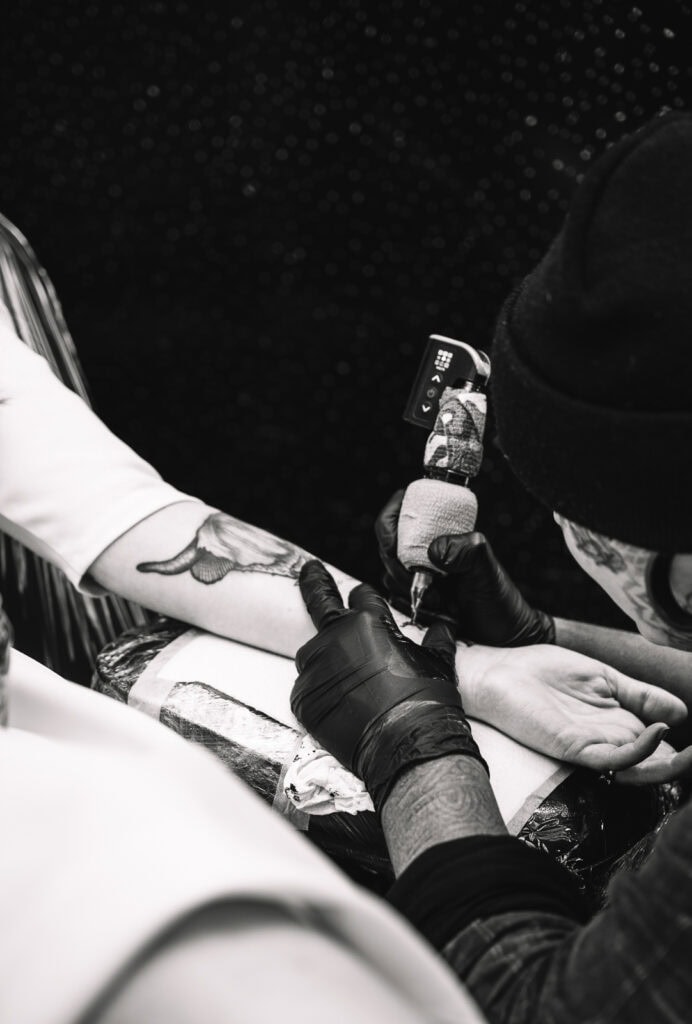 Tattoo artist creating wedding tattoo during celebration