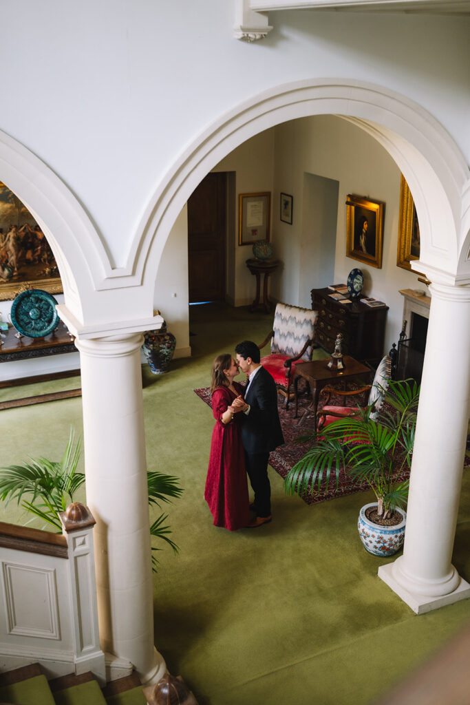 Couple standing together in elegant interior with arches.