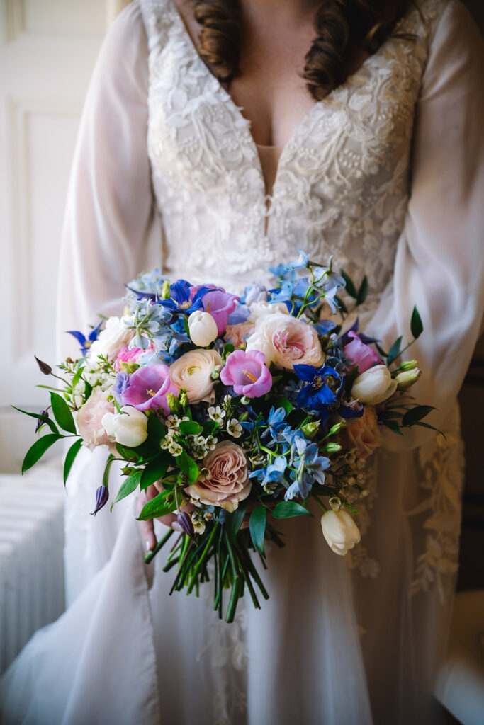 Close-up of colorful bridal bouquet with florals and greenery.