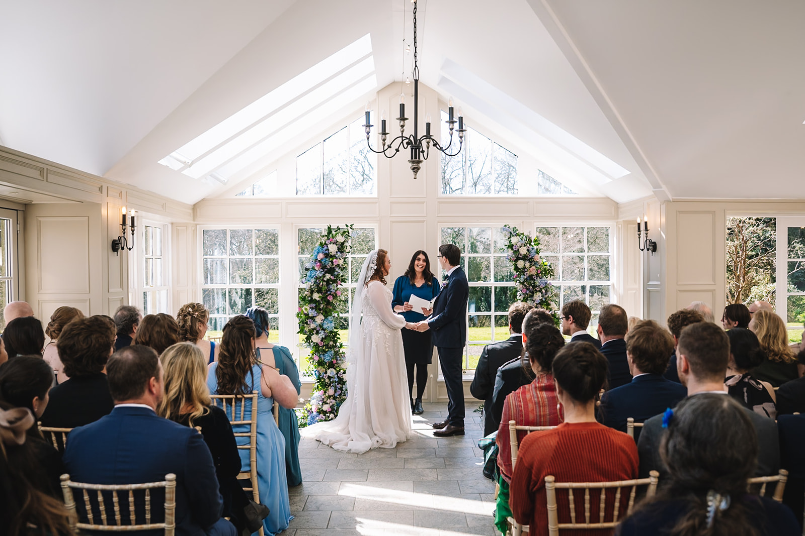 Couple standing at altar during ceremony with guests seated.